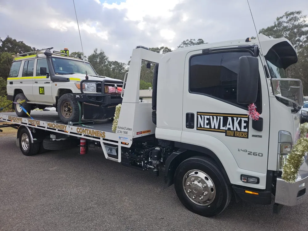 NewLake tilt tray carrying a white four-wheel drive